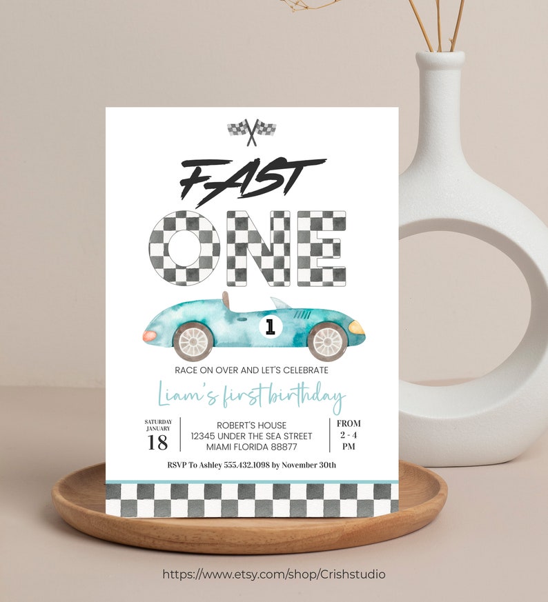Peut inclure: Une invitation d'anniversaire bleue et blanche avec un motif &agrave; carreaux et une voiture de course bleue de dessin anim&eacute;. L'invitation dit "Fast One" et "Liam's first birthday". L'invitation comprend la date, l'heure et le lieu de la f&ecirc;te.