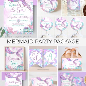 Pu&ograve; includere: Un pacchetto per feste a tema sirene con uno schema di colori viola e turchese. Il pacchetto include inviti, biglietti di ringraziamento, etichette per bottiglie d'acqua, topper per cupcake, un cartello personalizzato, sacchetti regalo e una scatola regalo. Il testo sull'invito recita "Oneder the Sea" e "Elizabeth's First Birthday".