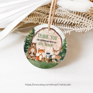 Pode incluir: Etiqueta redonda de agradecimento com tema de floresta. A etiqueta apresenta um urso marrom, uma raposa, um guaxinim e um veado em p&eacute; em um tronco de &aacute;rvore. O texto na etiqueta diz "Obrigado por celebrar conosco! Com amor, Robert."