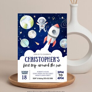 May include: A blue and white astronaut and rocket ship on a dark blue background with stars and planets. The text "JOIN US TO CELEBRATE CHRISTOPHER'S first trip around the sun" is at the top of the invitation. The text "SATURDAY JANUARY 18" is on the left side of the invitation. The text "ROBERT'S HOUSE 12345 UNDER THE SEA STREET MIAMI FLORIDA 88877 RSVP To Ashley 555.432.1098" is on the right side of the invitation. The text "2PM TO 4PM" is at the bottom of the invitation.