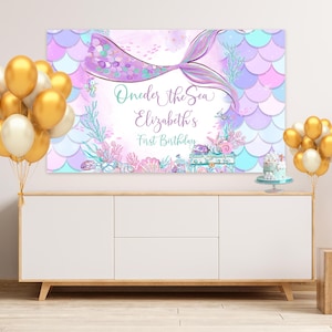 Peut inclure: Une queue de sir&egrave;ne violette et bleue avec des paillettes et des coquillages. Le texte "One-der the Sea Elizabeth's First Birthday" est sur la banni&egrave;re.