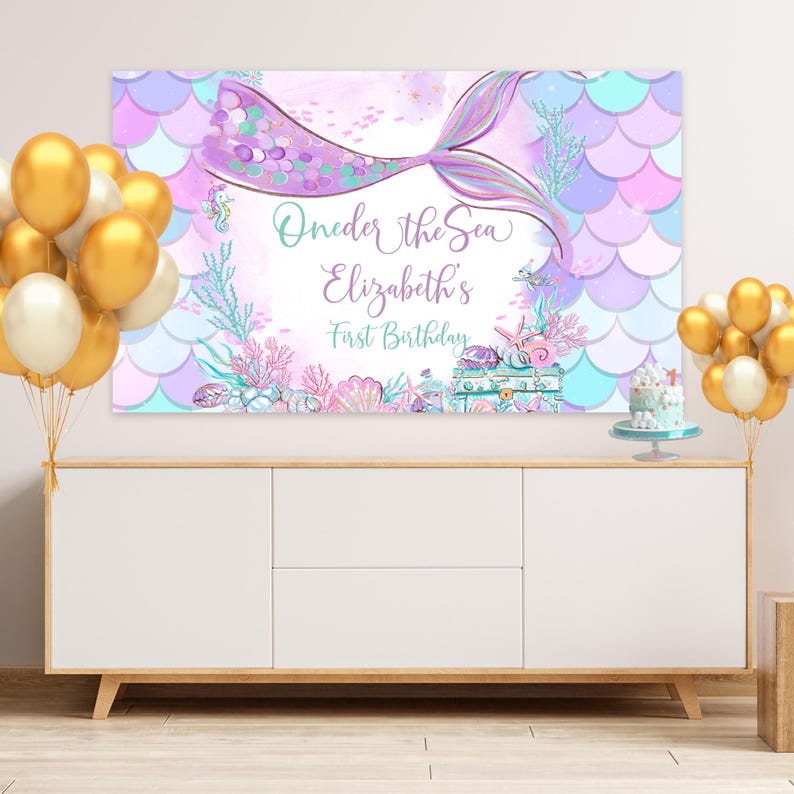 Peut inclure: Une queue de sir&egrave;ne violette et bleue avec des paillettes et des coquillages. Le texte "One-der the Sea Elizabeth's First Birthday" est sur la banni&egrave;re.