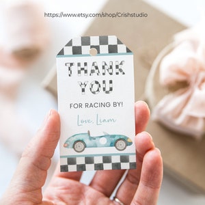 May include: Thank you for racing by!  A white gift tag with black and white checkered border, blue and white watercolor car illustration, and the text "Thank You for Racing By! Love, Liam".