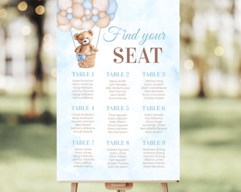 May include: A blue and beige seating chart with a teddy bear in a hot air balloon. The chart lists tables with names for each table. The text "Find your seat" is at the top of the chart.