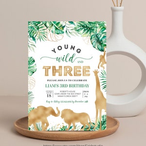 Puede incluir: Una invitaci&oacute;n de cumplea&ntilde;os con tem&aacute;tica de selva con detalles en dorado. La invitaci&oacute;n presenta un fondo de hojas verdes y doradas con un cuadro de texto blanco que dice "Young Wild and Three. Please join us to celebrate Liam's 3rd Birthday." La invitaci&oacute;n tambi&eacute;n incluye una silueta dorada de una jirafa, un mono, un elefante y un le&oacute;n.
