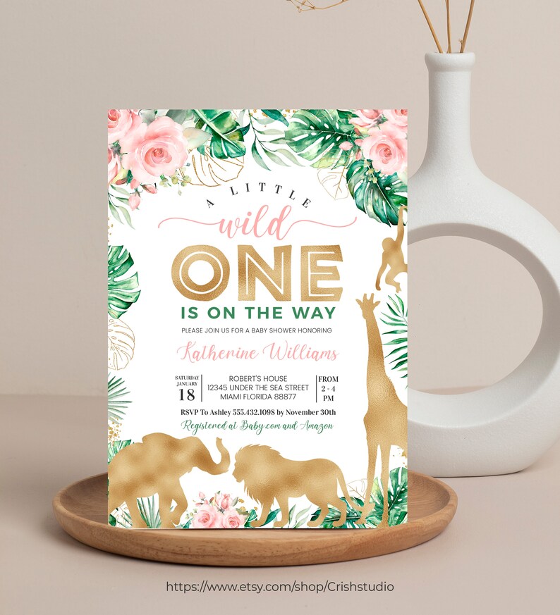 May include: A baby shower invitation with a jungle theme. The invitation features gold foil accents, pink flowers, and green leaves. The text reads "A Little Wild One Is On The Way" and includes event details.