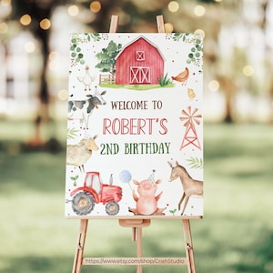 May include: A white welcome sign with a red barn, farm animals, and green foliage. The sign says "Welcome to Robert's 2nd Birthday".