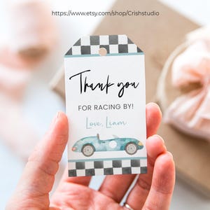 May include: Blue and white thank you tag with a checkered border. The tag features a watercolor illustration of a blue race car and the text "Thank you for racing by! Love, Liam".