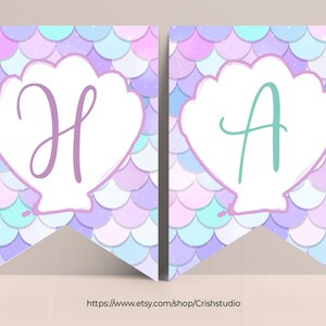 Pu&ograve; includere: Uno striscione a tema sirenetta con due pennoni che presentano una conchiglia bianca con una "H" viola e una "A" verde su uno sfondo di squame iridescenti viola, blu e bianche.