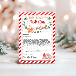May include: A red and white striped letter from Santa Claus to Liam. The letter is decorated with a green wreath and a red bow. The letter says "From the desk of Santa Claus" and "Dear Liam, Merry Christmas!" The letter is addressed to 4 Station Road.