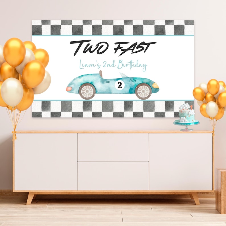 May include: A blue and white race car birthday banner with a checkered flag background. The banner says "Two Fast" and "Liam's 2nd Birthday".
