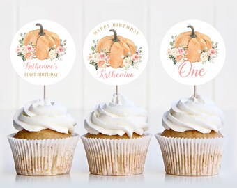 May include: Three cupcake toppers with a pumpkin, flowers, and the text "Happy Birthday", "Katherine", and "One".