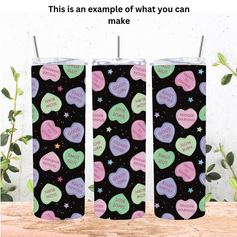 May include: Three stainless steel tumblers with a black background and a repeating pattern of colorful candy hearts with various phrases printed on them. The phrases include "Good Girl", "Slow Burn", "Trigger Warning", "Slut", "Smut", "Enemies to Lovers", "Villain Lover".