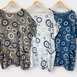 May include: Three loose-fitting, short-sleeved shirts with a floral print. The shirts are in brown, white, and blue.