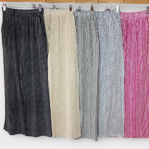 Puede incluir: Cinco pares de pantalones a rayas en diferentes colores, incluyendo negro, beige, azul y rosa. Los pantalones tienen una pierna ancha y un ajuste holgado.