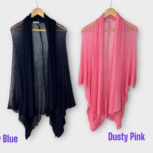 May include: Two open-front cardigans, one navy blue and one dusty pink, hang on wooden hangers. The navy blue cardigan is on the left, and the dusty pink one is on the right. The words "Navy Blue" and "Dusty Pink" are written below the cardigans.