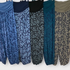 Op de afbeelding: Vijf paar losse, bedrukte broeken met elastische tailleband. De broeken zijn in verschillende tinten blauw, teal en grijs met een bladmotief.