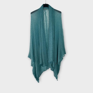 May include: A teal shawl hangs on a black hanger against a white backdrop. The shawl features a draped design with a flowing, open front. The fabric looks lightweight and slightly textured, with a subtle sheen. The garment is a wrap.