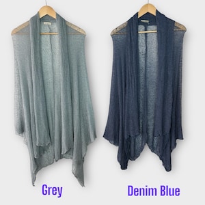 May include: Two open-front cardigans in grey and denim blue, displayed on wooden hangers. The grey cardigan is on the left, and the denim blue cardigan is on the right. The text "Grey" and "Denim Blue" are below each cardigan.