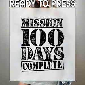 May include: White t-shirt with black text that reads "Mission 100 Days Complete". The text is in a distressed font style.
