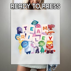 May include: White sublimation print featuring characters from the movie Inside Out. The words "READY TO PRESS" are at the top. The phrase "TEAM RILEY" is spelled out with individual letter cards, surrounded by the movie's characters.