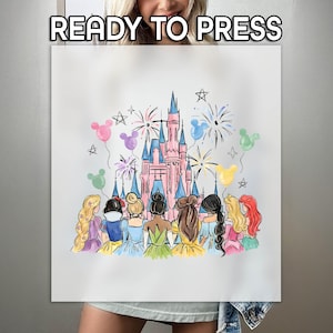 May include: A white ready-to-press transfer featuring a watercolor illustration of a pink castle, fireworks, and colorful balloons. The design includes several princesses from behind. The text "READY TO PRESS" is at the top.