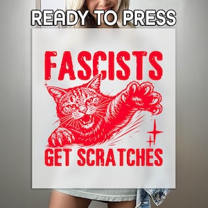 May include: A white poster with the text "READY TO PRESS" at the top. The poster features a red illustration of an angry cat with the words "FASCISTS GET SCRATCHES" in bold red letters. The cat is mid-scratch, with claws extended.