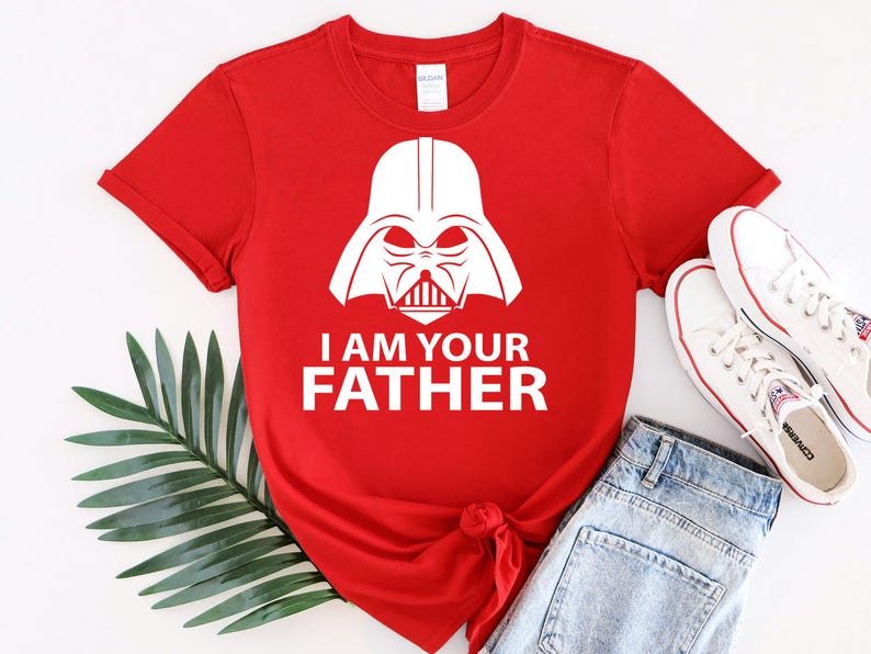 May include: Red t-shirt with a white graphic of Darth Vader's helmet and the text "I am your father".