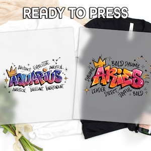 May include: Two heat transfer designs for t-shirts. One features the word "AQUARIUS" in graffiti style with a crown and descriptive words. The other design says "ARIES" in graffiti style with a crown and descriptive words. The text "READY TO PRESS" is at the top.