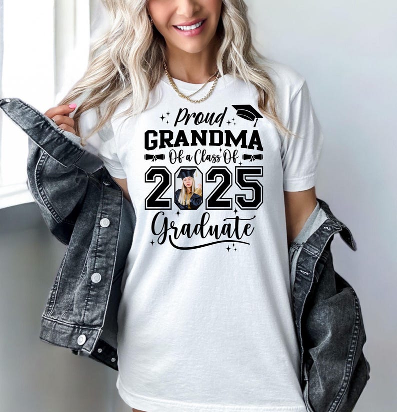 May include: White t-shirt with black text that reads "Proud Grandma of a Class of 2025 Graduate". A graduation cap icon is above the word "Proud" and a photo of a graduate is in the number 2025.
