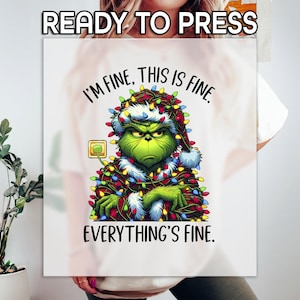 May include: White t-shirt with a green Grinch character tangled in Christmas lights. The Grinch is wearing a Santa hat and has a grumpy expression. The text on the shirt reads "I'm fine. This is fine. Everything's fine."