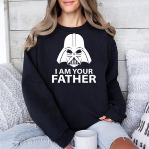 May include: Black sweatshirt with a white graphic of Darth Vader's helmet and the text "I am your father."