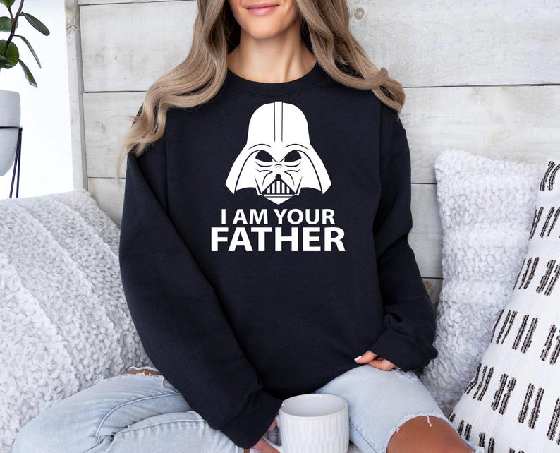 May include: Black sweatshirt with a white graphic of Darth Vader's helmet and the text "I am your father."