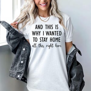 May include: White t-shirt with the text "AND THIS IS WHY I WANTED TO STAY HOME all this, right here." The shirt is paired with a dark denim jacket. The overall style is casual and comfortable.