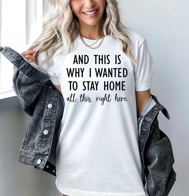 May include: White t-shirt with the text "AND THIS IS WHY I WANTED TO STAY HOME all this, right here." The shirt is paired with a dark denim jacket. The overall style is casual and comfortable.