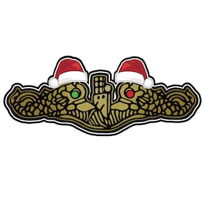 Puede incluir: Un insignia de guerra submarina de oro con dos gorros de Papá Noel rojos y blancos en la parte superior. El insignia tiene una luz verde y roja a cada lado.