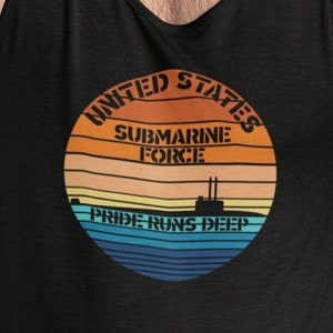 Puede incluir: Camiseta sin mangas negra con un diseño gráfico circular. El diseño presenta un atardecer con las palabras "United States Submarine Force" y "Pride Runs Deep". Incluye una silueta de submarino.
