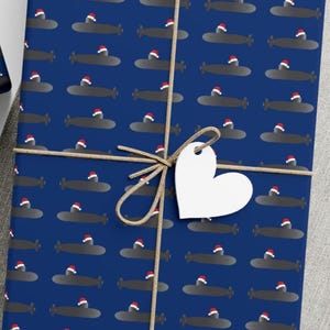 Gorro de Papá Noel de la Fuerza Submarina de los Estados Unidos sobre papel de regalo azul de minisubmarinos grises
