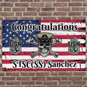 May include: A red, white, and blue American flag with a skull and crossbones design. The flag has the words "Congratulations" at the top, "USN" on each side, and "STSC(SS) Sanchez" at the bottom.