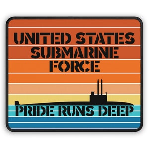 Puede incluir: Un ratón de ordenador negro y naranja con un diseño retro de puesta de sol. El texto "UNITED STATES SUBMARINE FORCE" está en la parte superior, y el texto "PRIDE RUNS DEEP" está en la parte inferior. Una silueta de un submarino está en el centro.