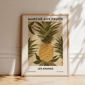 Peut inclure: Une affiche encadrée avec une illustration vintage d'un ananas avec le texte "Marché aux Fruits" et "Les Ananas" en noir sur un fond beige.
