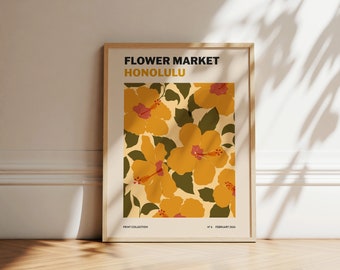 May include: A framed print with a floral design featuring yellow hibiscus flowers with red centers on a cream background. The text "FLOWER MARKET HONOLULU" is at the top of the print. The print is labeled "PRINT COLLECTION" and "N° 6 FEBRUARY 2024" at the bottom.