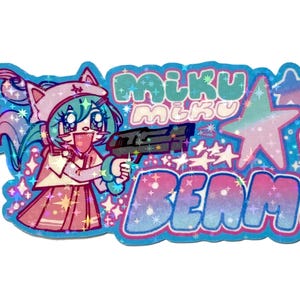 Könnte beinhalten: Ein holografischer Aufkleber mit einem Anime-Charakter mit türkisfarbenem Haar und einem rosa Outfit, der eine schwarze Waffe hält. Der Aufkleber trägt die Aufschrift "miku miku BEAM!" in einer stilisierten Schriftart, mit Sternen und Glitzer.