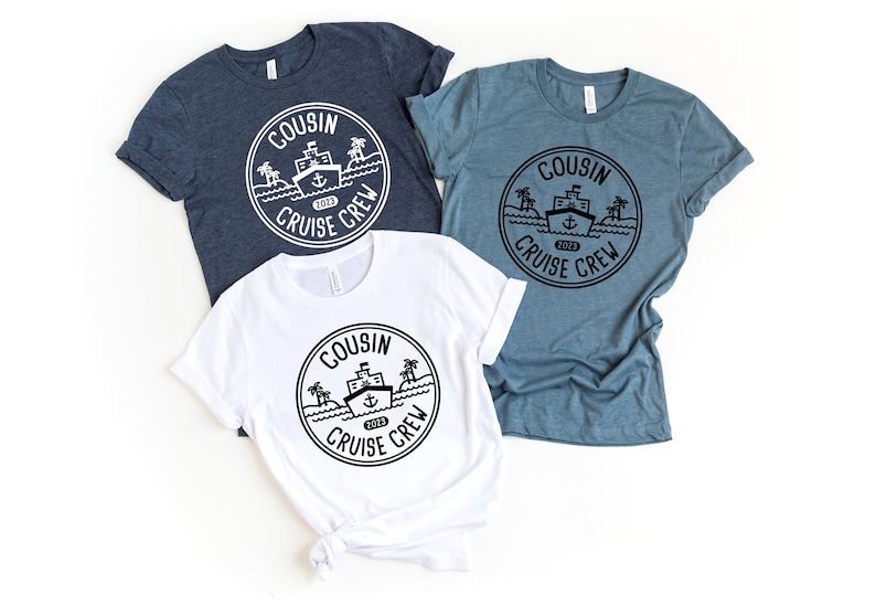 May include: Three t-shirts featuring a black and white graphic of a ship with palm trees and the text "COUSIN CRUISE CREW 2023" in a circle. The shirts are white, dark blue, and light blue.