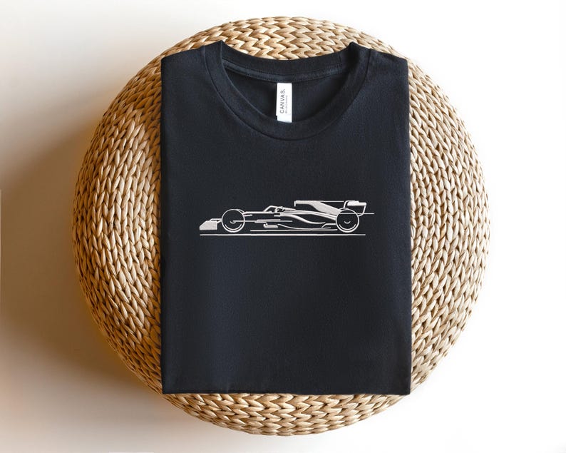 May include: Black t-shirt with a white outline of a racing car.
