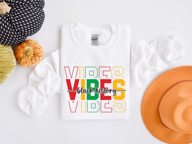 May include: White sweatshirt with the words "VIBES" in red, yellow, green, and black, stacked on top of each other. The words "black history" are written in black cursive script between the two "VIBES" words.