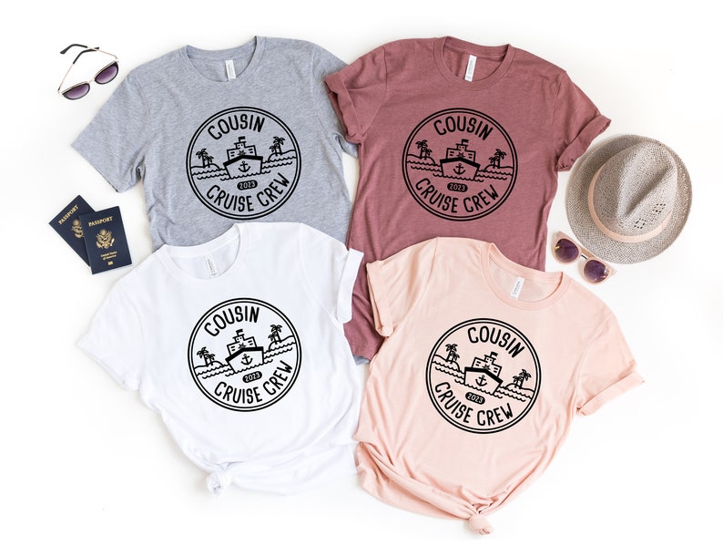 May include: Four t-shirts featuring a black and white graphic of a ship with palm trees and the text "Cousin Cruise Crew 2023". The shirts are in grey, maroon, white, and peach.