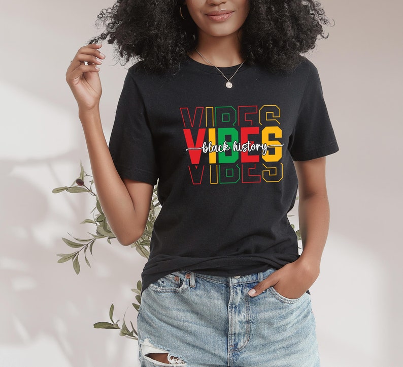 May include: Black t-shirt with the text "VIBES" in red, yellow, green, and black letters. The text "black history" is written in white script across the middle of the shirt.