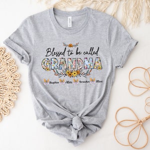May include: Gray t-shirt with the text "Blessed to be called GRANDMA" in floral letters. The names Sophia, Alex, Braden, and Olive are written below the text.