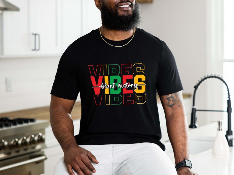 May include: Black t-shirt with the words "Vibes" in red, yellow, green, and black, with the words "Black History" written in white cursive script.